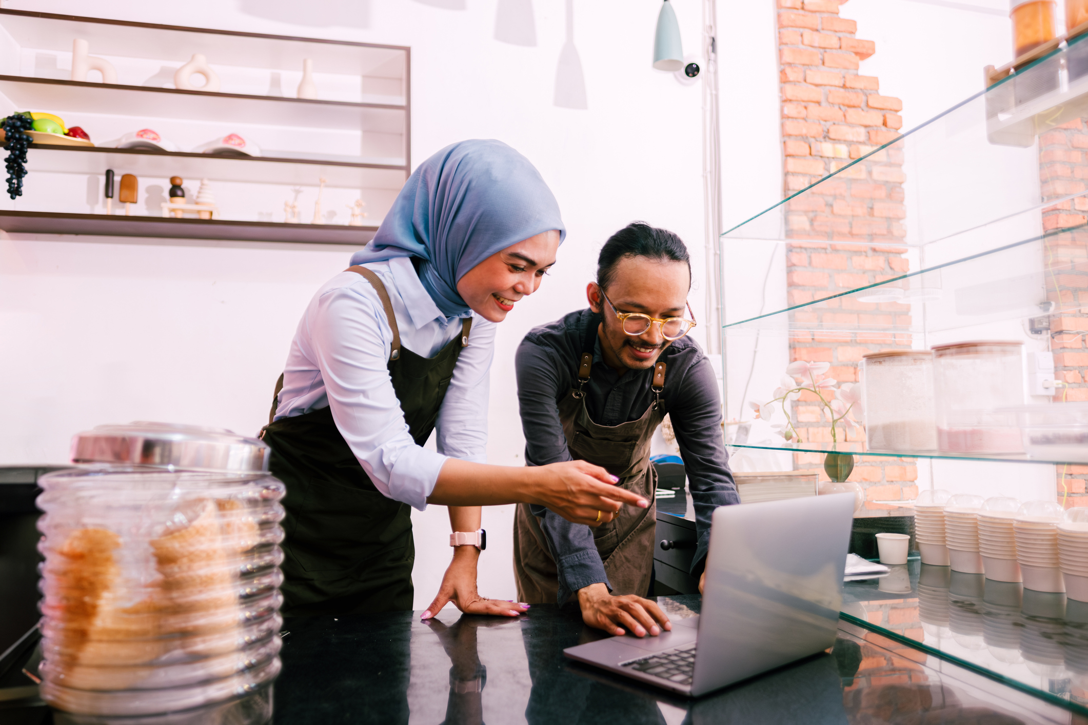 Two shop owners looking at a laptop