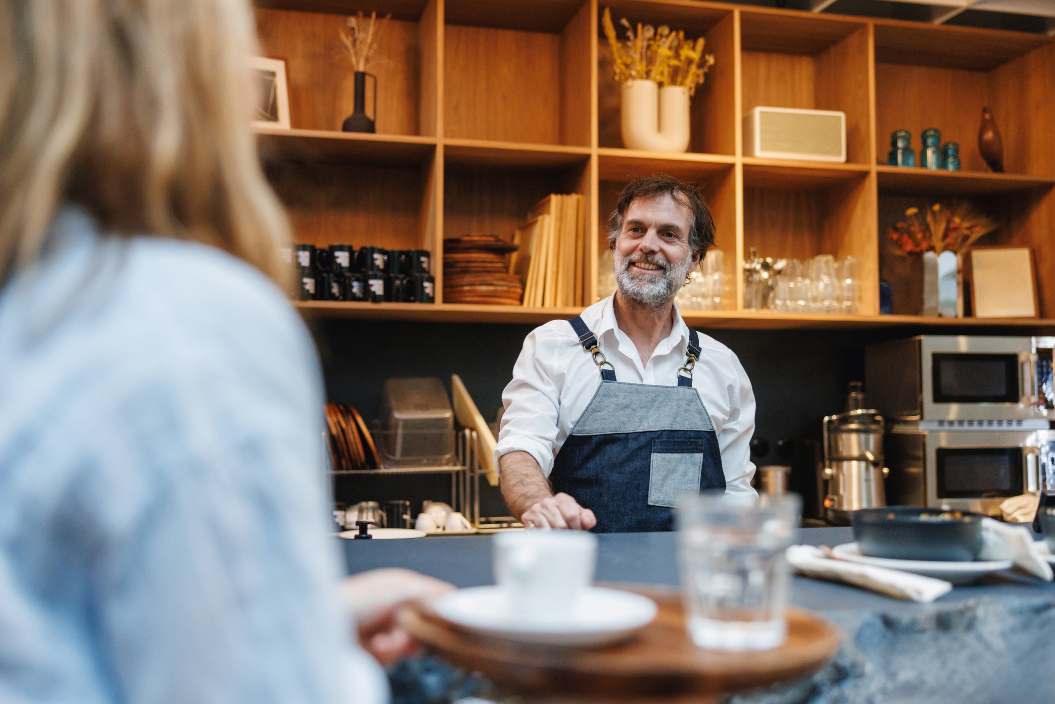 A man serving up a cup of coffee in a cafe